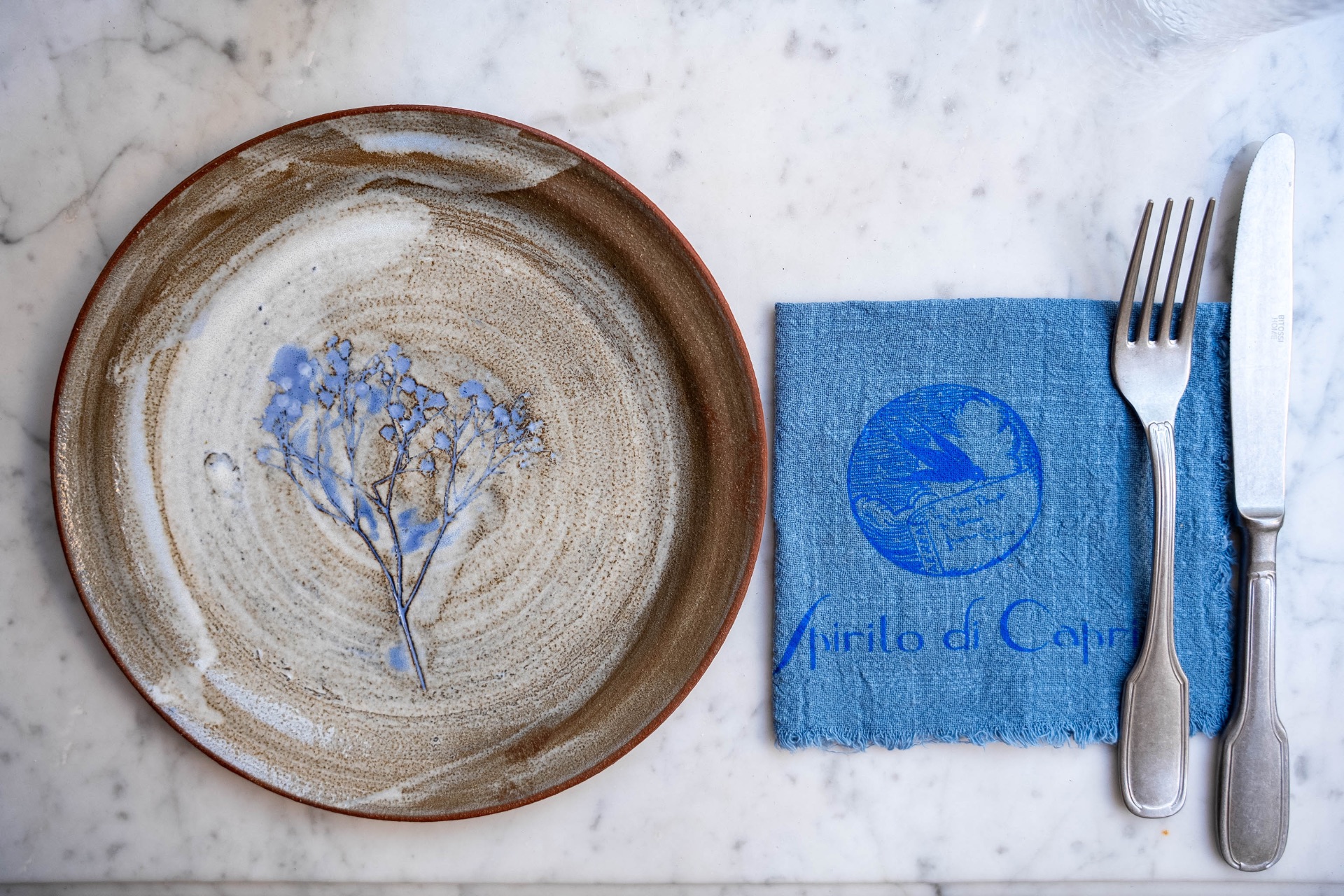 Mise en place elegante con ceramica e tovagliolo blu